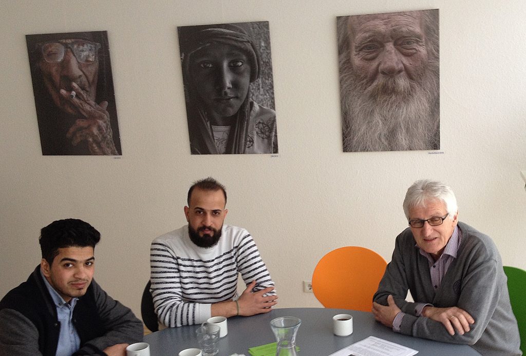Qassim Mohammad (Mitte) mit Werner Kölchens (rechts), Hobbyfotograf und ehrenamtlicher Helfer beim Pressegespräch am 02.03. in der Begegnungsstätte, Bleichpfad 15c